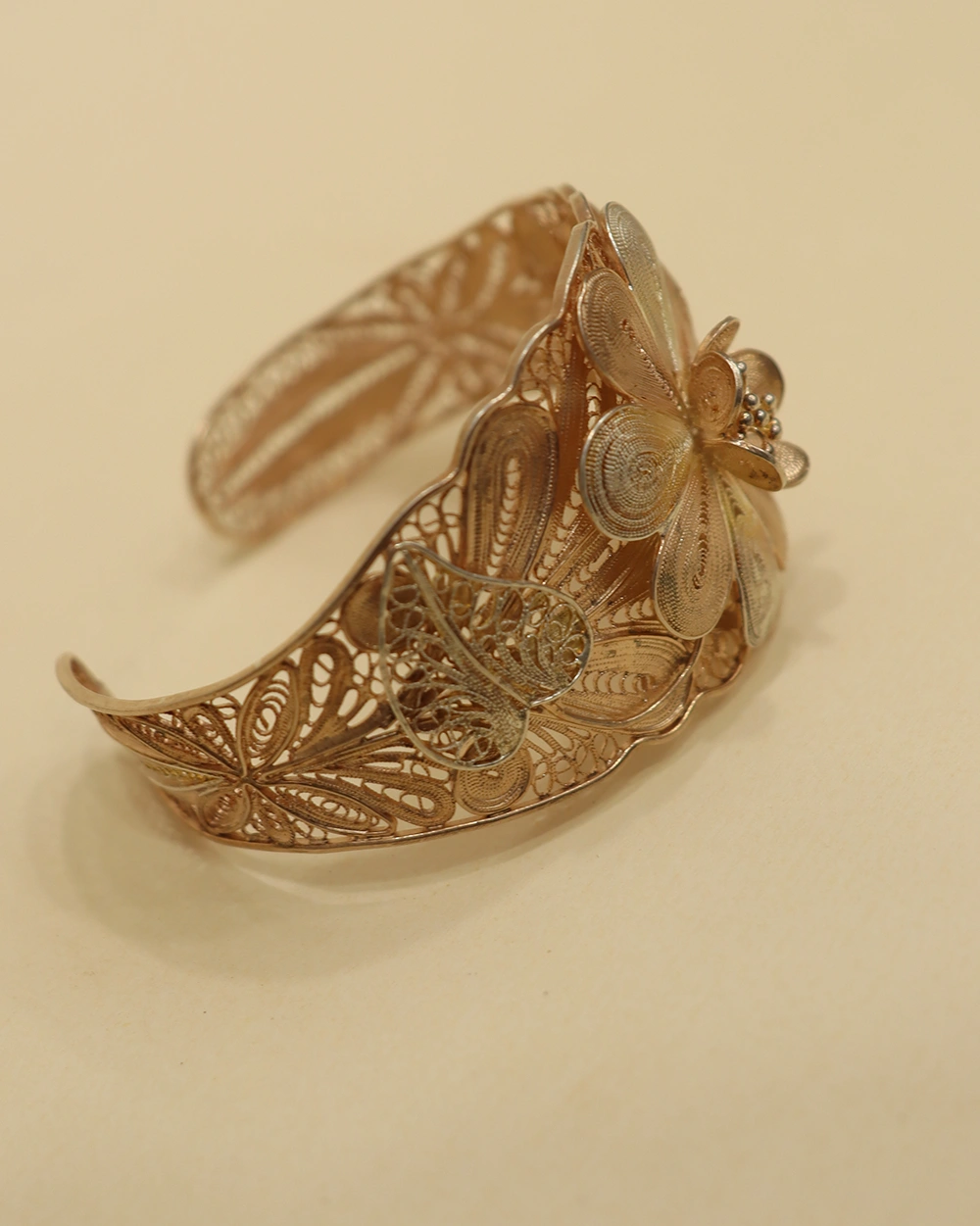 Woman wearing gold filigree flower cuff bracelet in 925 sterling silver