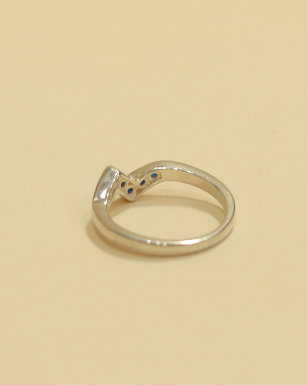 Woman wearing delicate 925 sterling silver blue stone wave ring